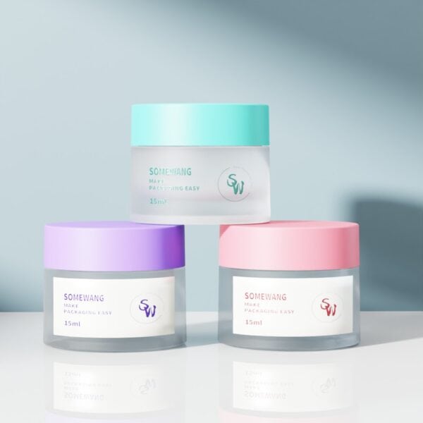 Three 15ml frosted double-wall jars with pastel mint, lavender, and pink lids on a soft gradient background.