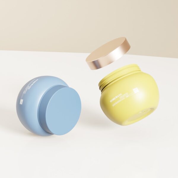 Un pot cosmétique bleu de 250 ml avec couvercle fermé et un pot jaune avec couvercle doré flottant sont représentés sur une surface blanche.