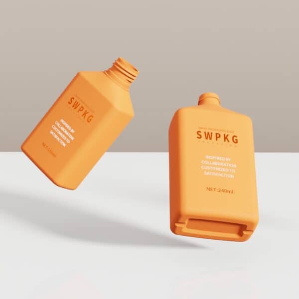 Two orange flat square bottles with lids, one upright and one tilted, on a white surface against a neutral background.