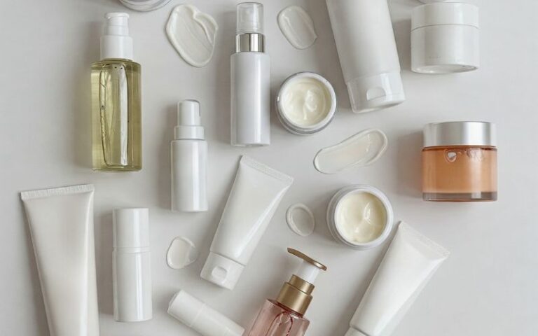 Clean skincare cream and lotion jars with white tubes and bottles arranged neatly on a white background, showcasing beauty products suitable for moisturizing and skin care routines.